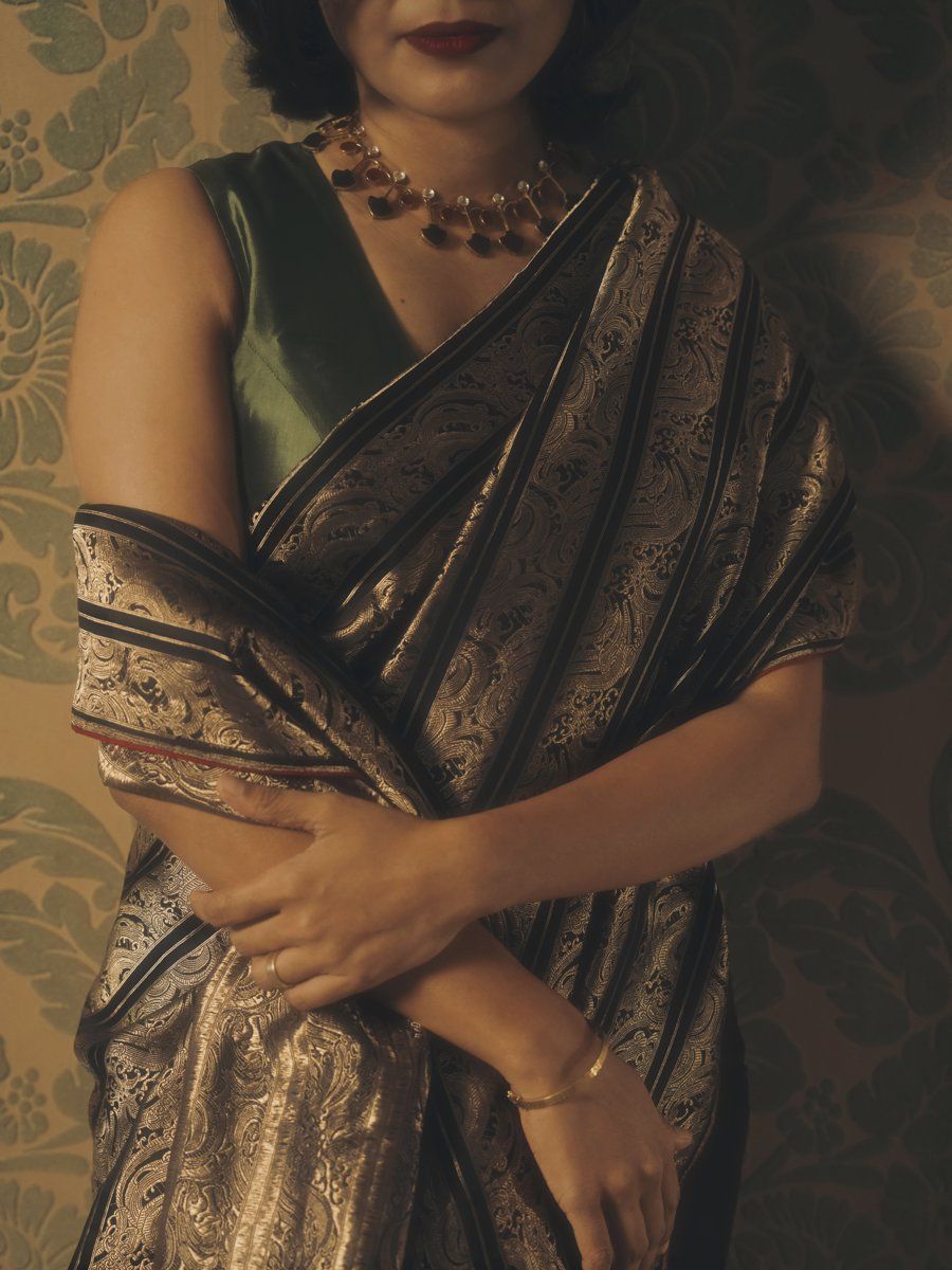 Black and gold brocade saree, arms crossed