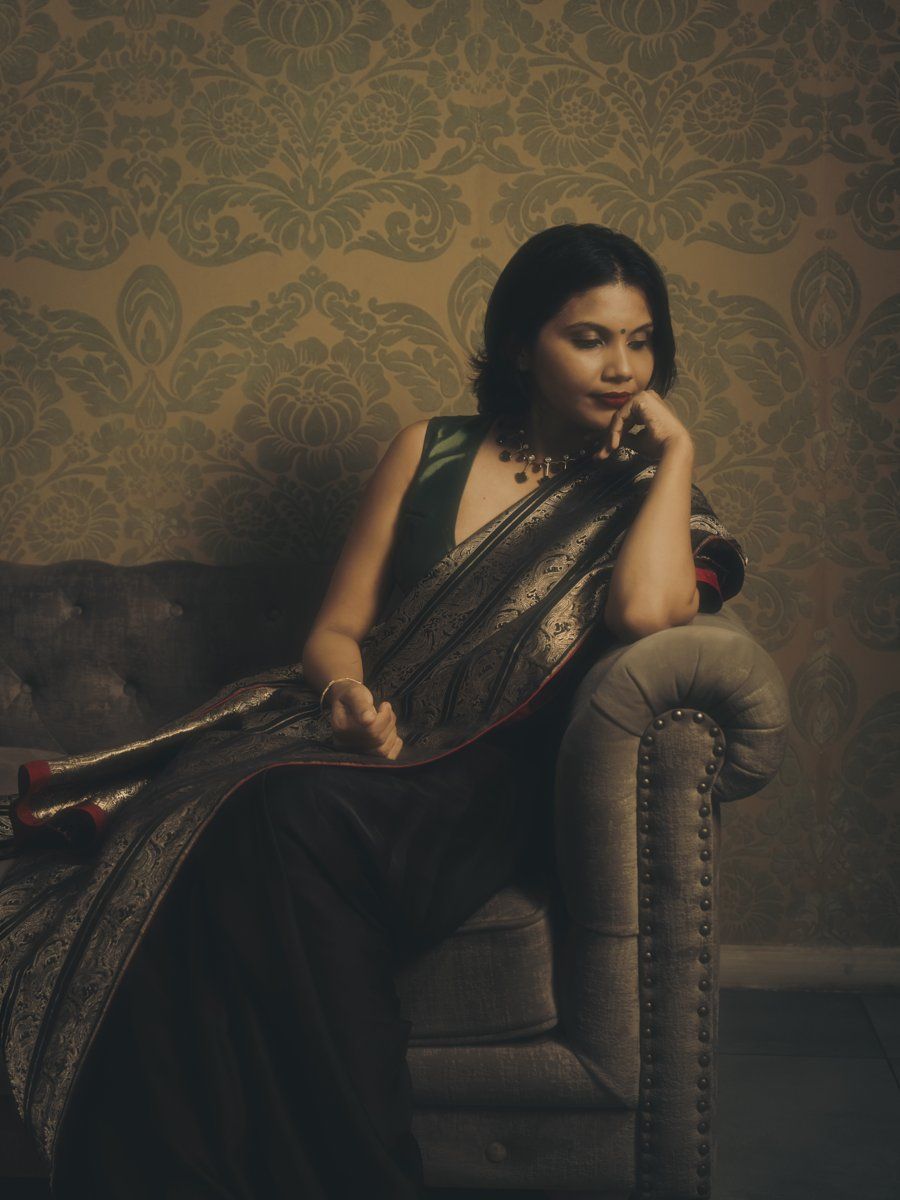 Deepa V Thomas, seated portrait in a brocade saree